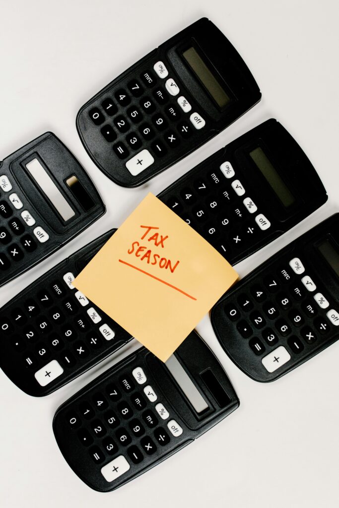 Top view of black calculators arranged around 'Tax Season' sticky note, perfect for finance concepts.